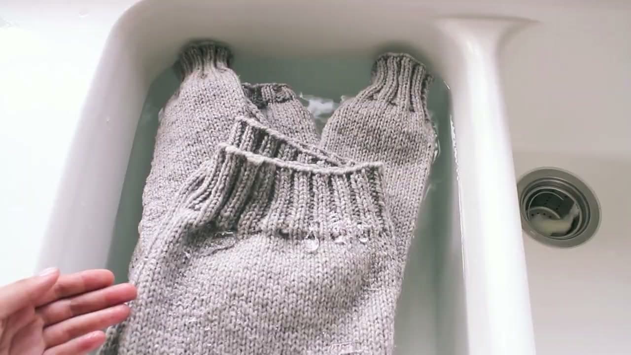 Step 1: Lower the Knitted Sweater Into a Sink of Room Temperature Water - How to Block Knitting